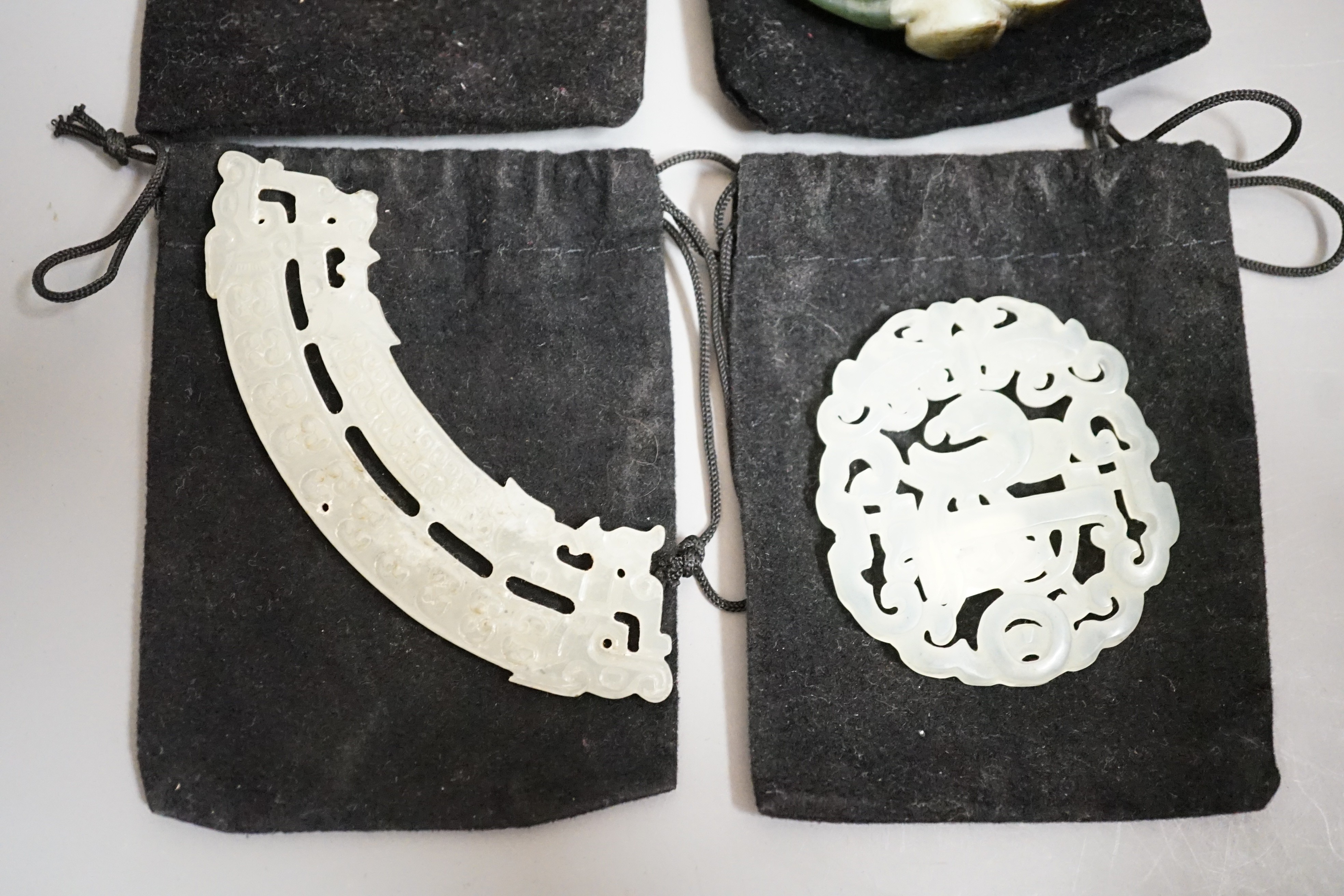Three Chinese jade celadon roundels/pendants and a huang plaque, carved dragon roundel 5.5 cms diameter (4)